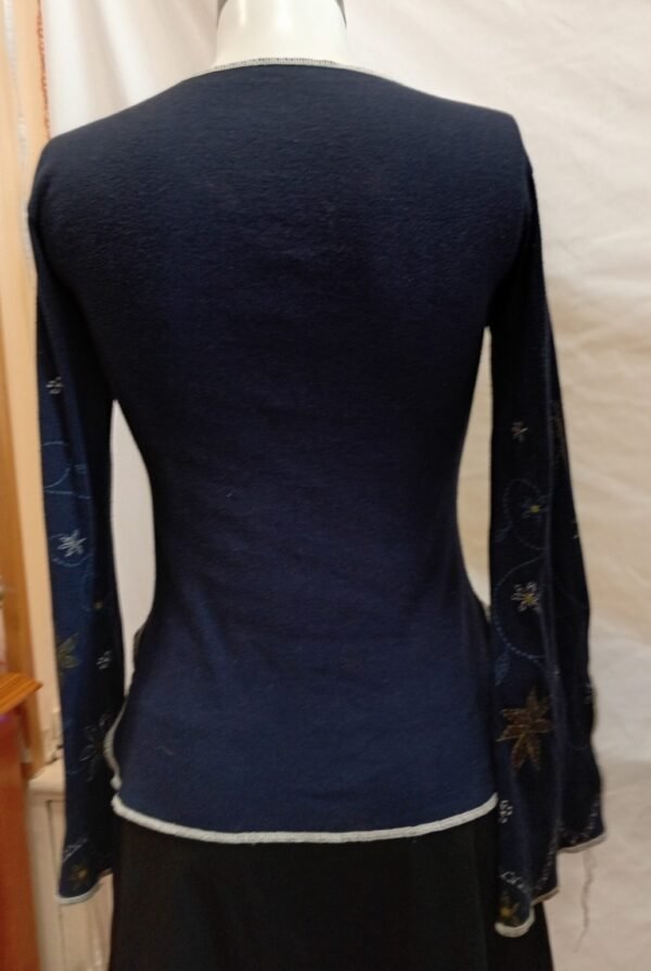 top azul marino manga larga con bordado floral y acabado ondulado talla S